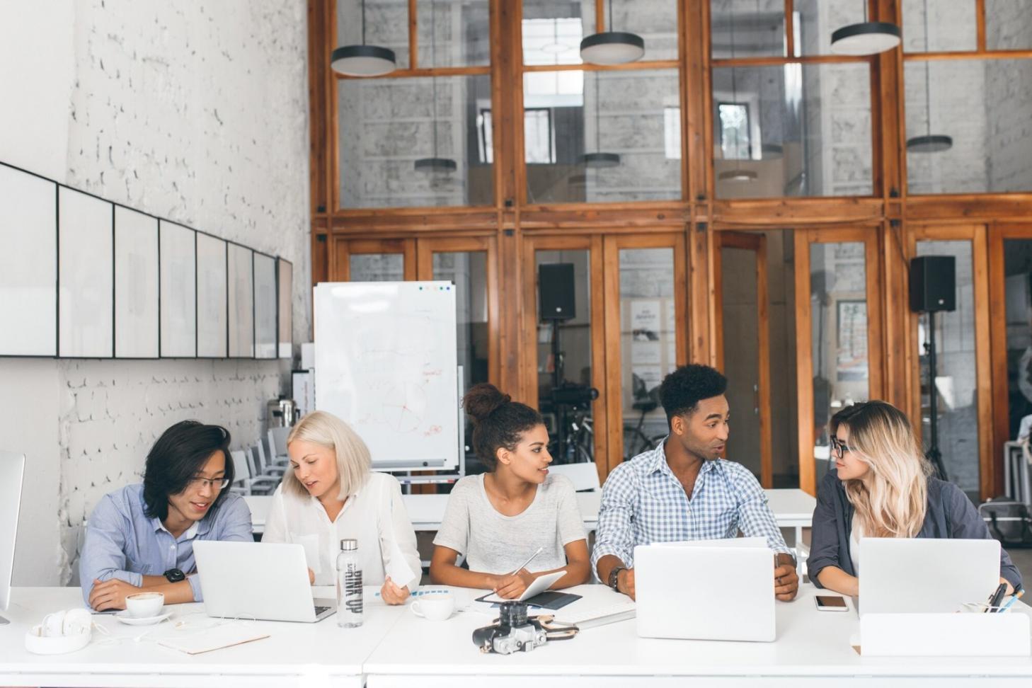 Professional meeting room with financial documents and charts spread across a conference table