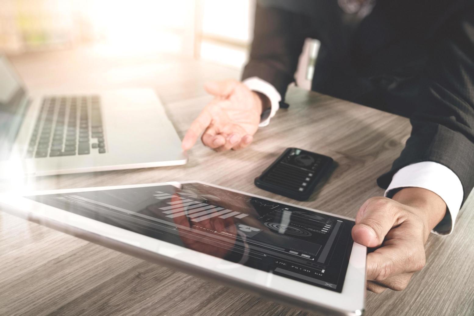 Business professionals reviewing financial presentations and communication materials in a modern office setting